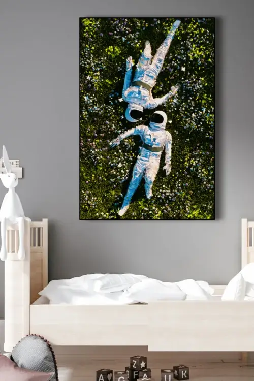 Large surreal astro wall art hangs above the bed on gray wall in kids room