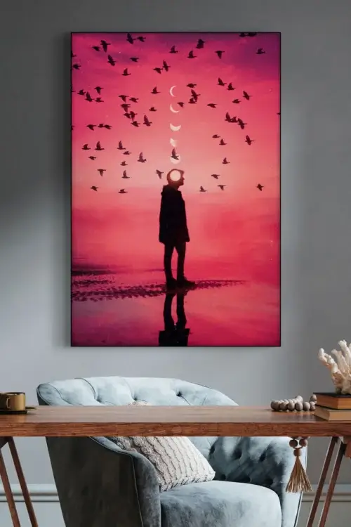 Large red phases of the moon wall art hangs above desk in home office decorated in grey.