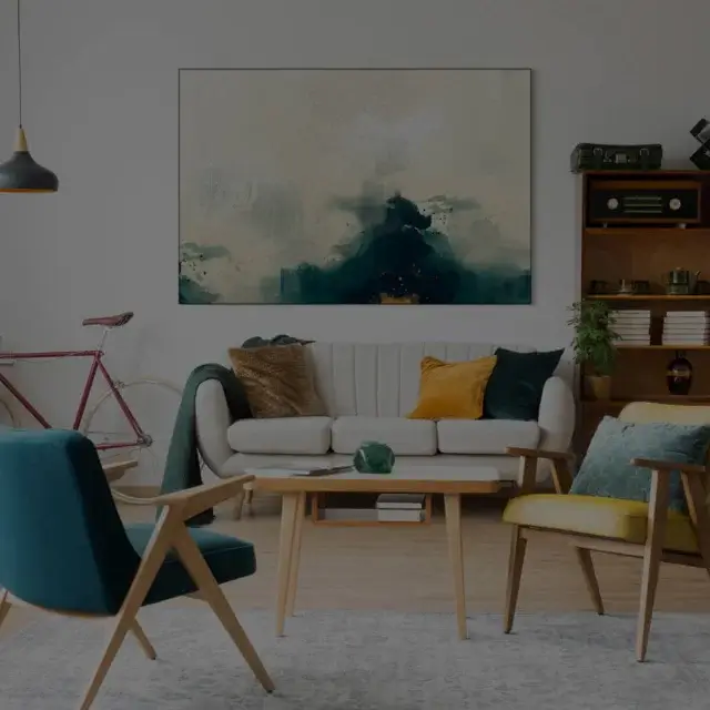 Artwork hanging on modern living room wall above couch features a color palette of blue, white, with accents of gold.