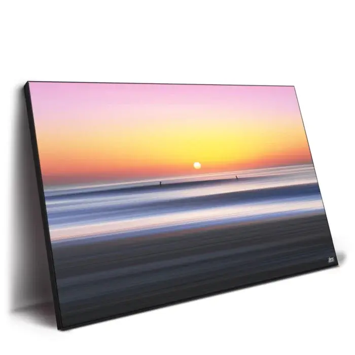 Vibrant orange and pink sharing sunset over a serene seascape.