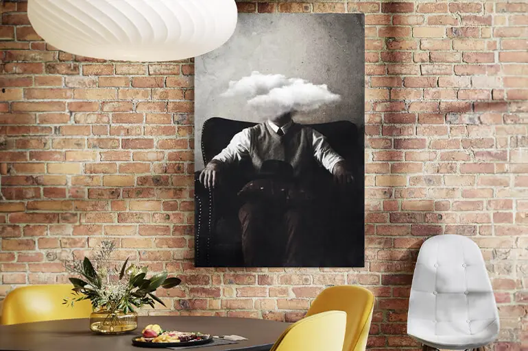 A modern office space featuring a surreal black and white portrait of a seated man with a cloud replacing his head, adding a thought-provoking and artistic touch.