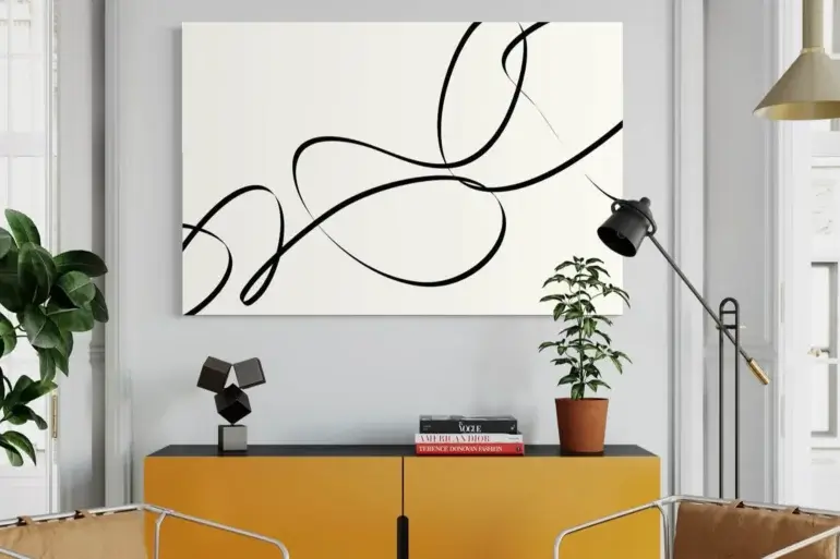 Huge line drawing of elegant black lines on white background hangs in modern living room above yellow sideboard