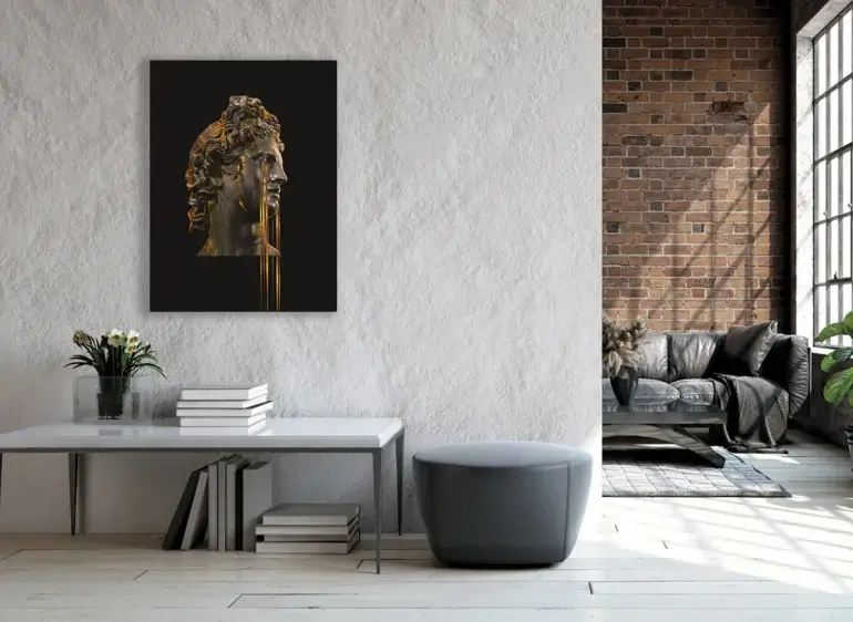 Large Greek hpistoric art in black and gold hangs o grey wall above accent table decorated with books and white roses on apartment living room wall.