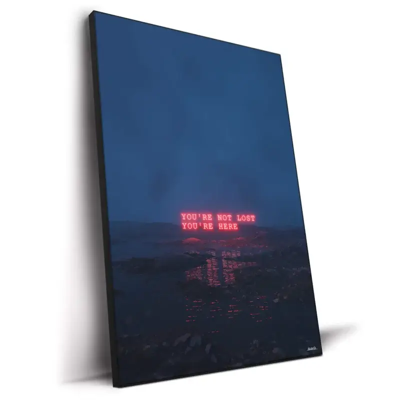 A twilight seascape with the words "YOU'RE NOT LOST, YOU'RE HERE" glowing on the water's surface.