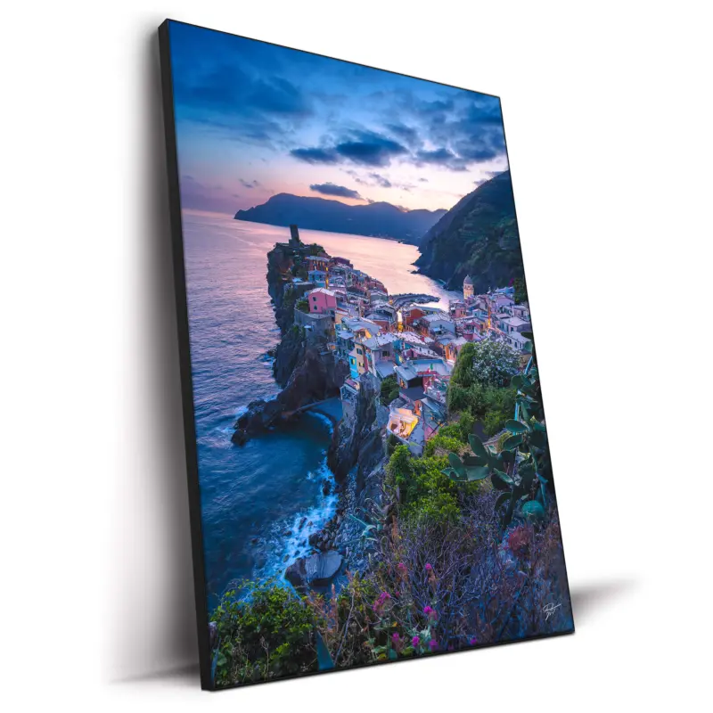 Vernazza village in Italy at sunset with colorful buildings by the sea.