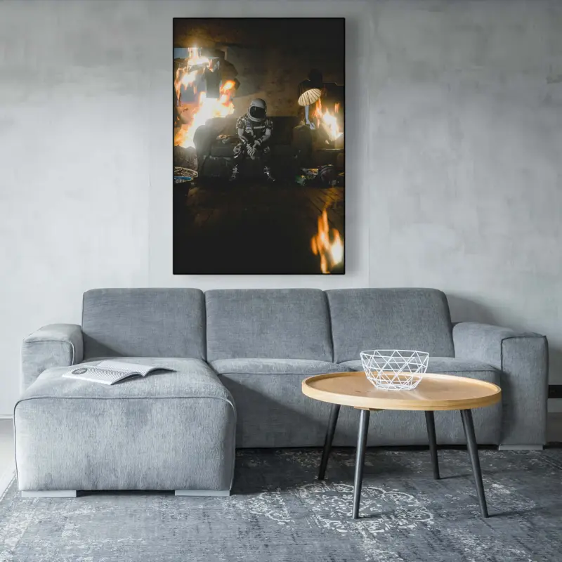 Oversized surreal astronaut art of astro in burning house hangs above gray couch