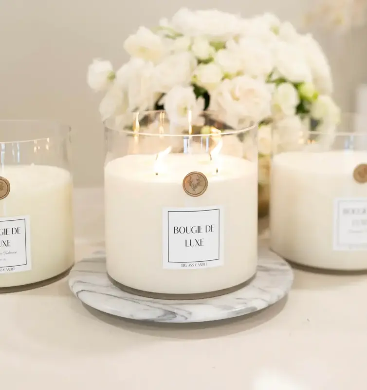 Three big ass candles sit on white counter in neutrally decorated living room