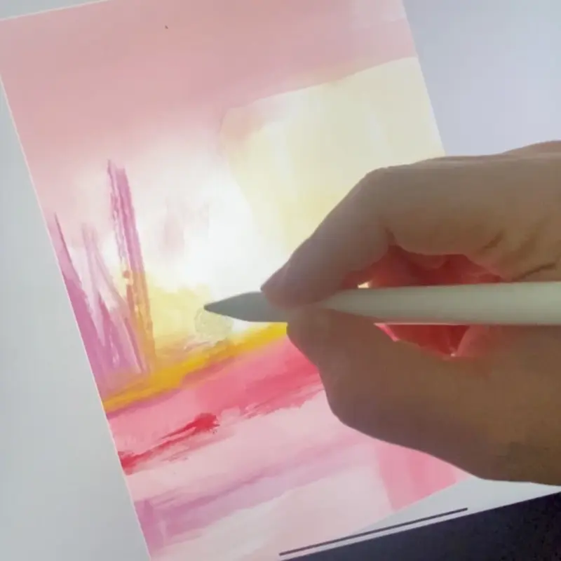 Close-up shot of abstract artist Karine Tonial Grimm's hand holding a white Apple pen and adding yellow to a pink abstract artwork on an iPad. The artist's precise movements can be seen as she creates her piece