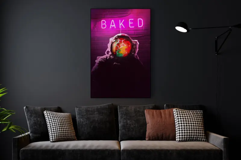 Large trippy wall art featuring a neon pink sign that reads "BAKED" above an astronaut's head hangs on living room wall above a couch.